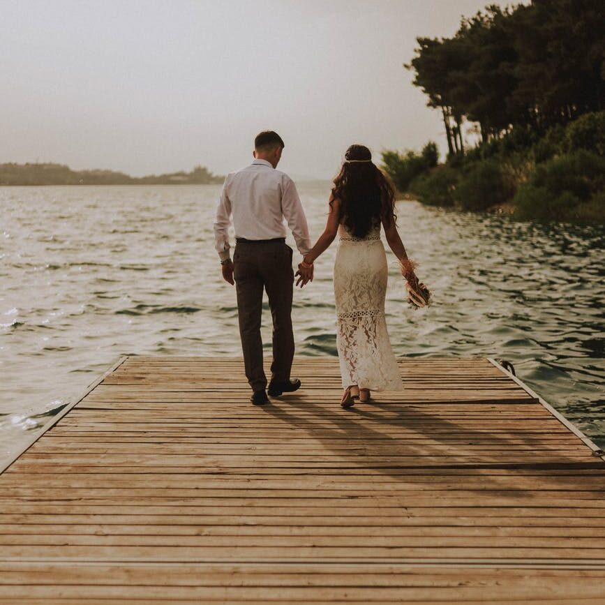 photo of couple standing on wooden planks